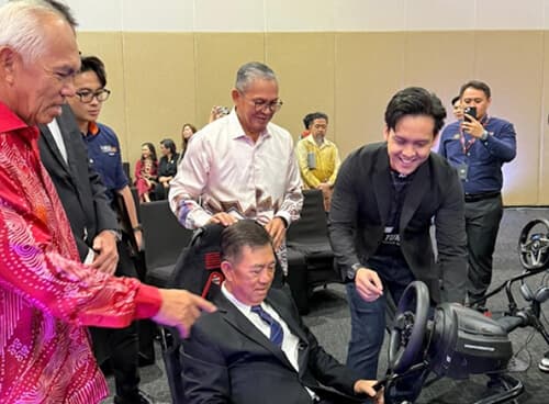 Corporate guests trying a sim racing rig at a company event in Sabah